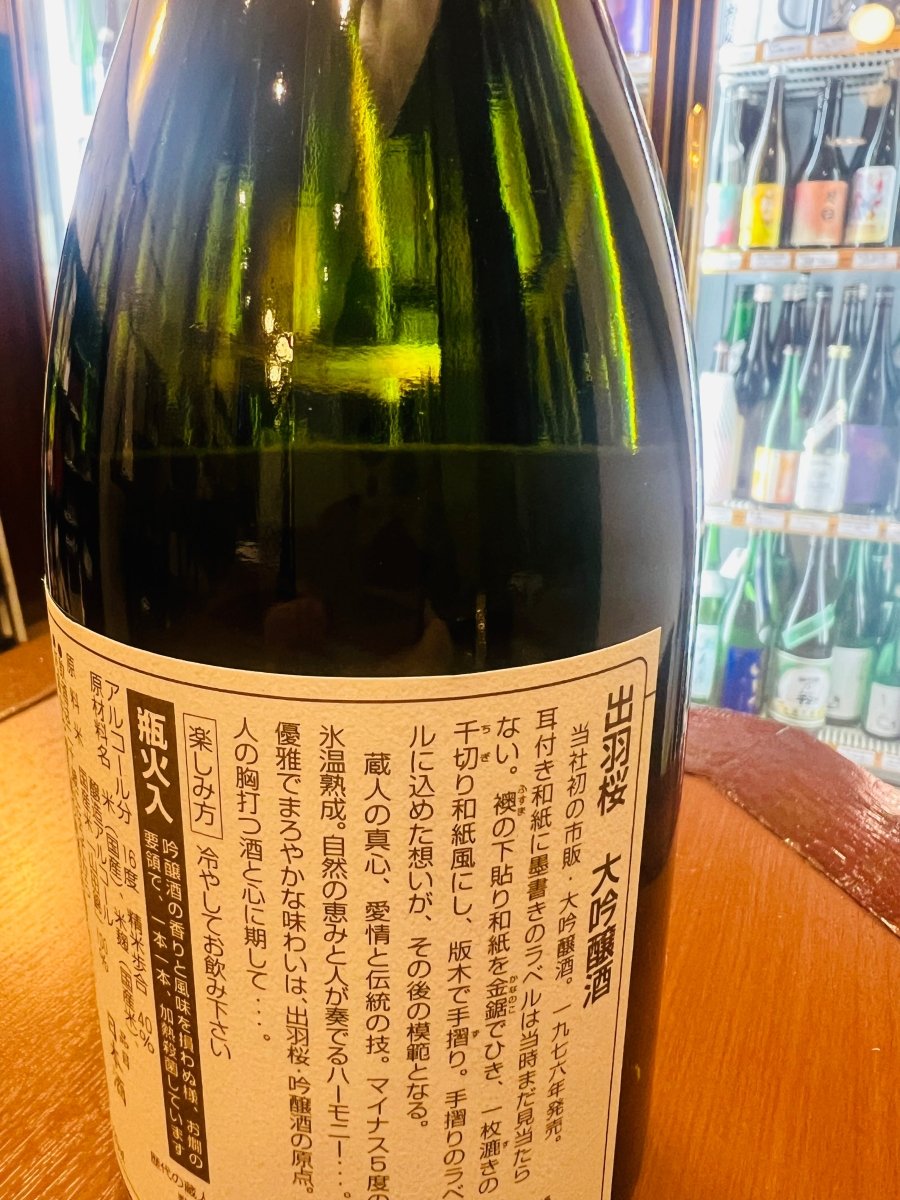 「出羽桜 大吟醸」720mlの裏面ラベル。1976年に発売された当社初の市販大吟醸酒であり、手すき和紙ラベルの先駆けとなった歴史が記されています。マイナス5度の氷温熟成によって生まれる優雅でまろやかな味わいについて説明されており、精米歩合40％、アルコール分16度といった品質情報が確認できる接写画像です。