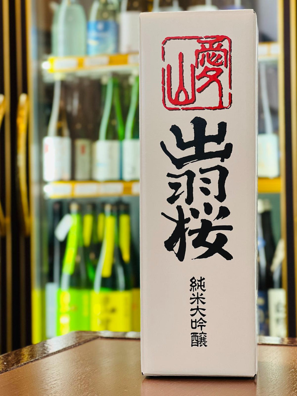 出羽桜 純米大吟醸 愛山 720mlの専用化粧箱正面。「出羽桜」「純米大吟醸」の文字と赤い印章を大きく配した白色の化粧箱で、贈答用にも使いやすい専用箱。