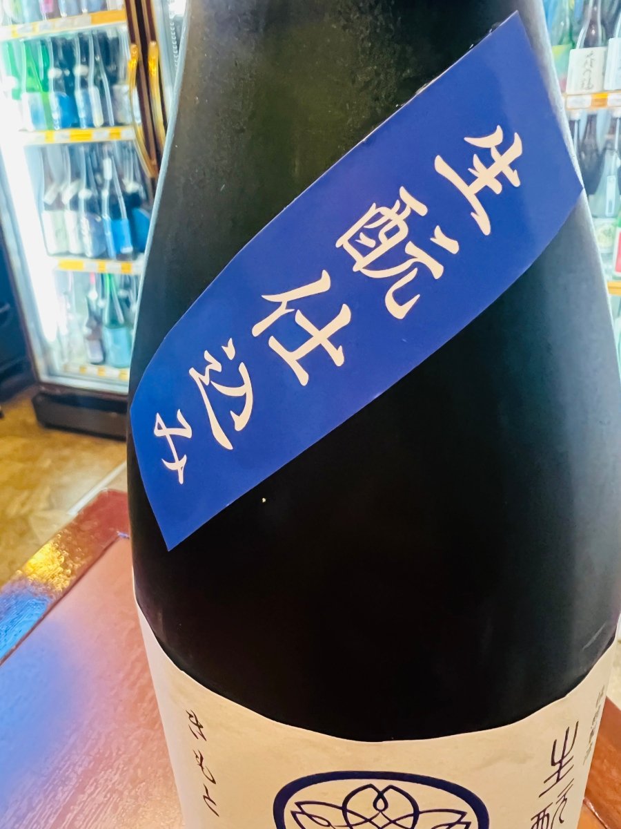 出羽桜「純米大吟醸」のボトル肩部分に貼られた、「生酛仕込み」と記された鮮やかな青色のラベル。伝統的な造りである生酛（きもと）ならではの、芯の強い酒質と奥深い旨味を表現したこだわりの証です。