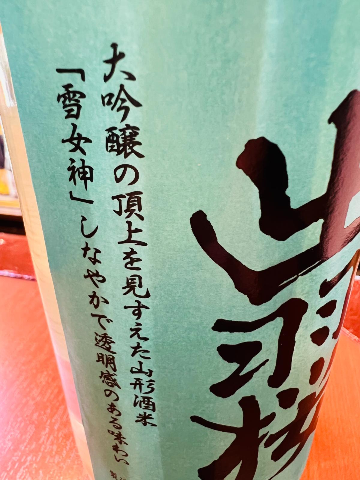 出羽桜 純米大吟醸 雪女神 生詰のラベル側面接写。「大吟醸の頂上を見すえた山形酒米『雪女神』 しなやかで透明感のある味わい」と、使用米と酒質のコンセプトが記されている。