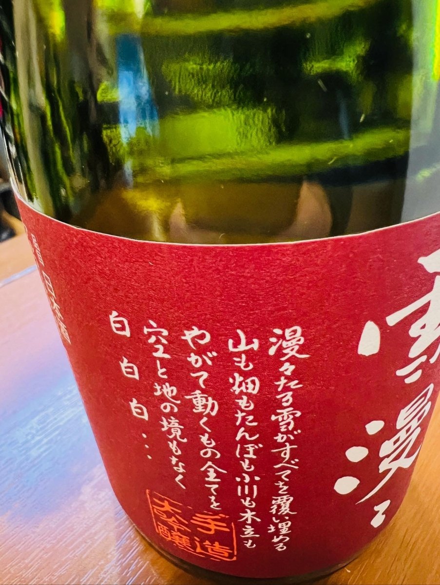 山形・出羽桜酒造「純米大吟醸 雪漫々（ゆきまんまん）」のラベル側面詳細。「漫々たる雪がすべてを覆い埋める 山も畑もたんぼも ふり川も木立も やがて動くもの全てを 空と地の境もなく 白 白 白･･･」という、雪深い冬の情景を綴った美しい詩が記されています。蔵の厳しい寒さの中で、低温でじっくりと醪（もろみ）を育てた、手造りへのこだわりと静かな情熱を伝える画像です。