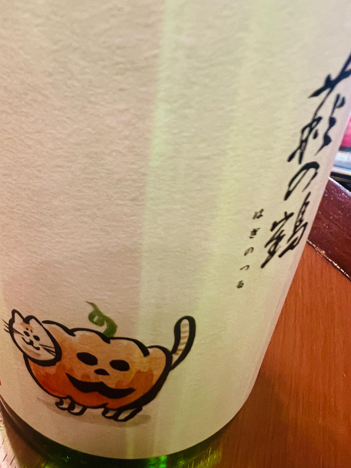 萩の鶴 別仕込 ハロウィン猫の正面ラベル接写。「萩の鶴」の銘柄ロゴと、かぼちゃをまとった猫のイラストが描かれた、宮城県・萩野酒造の秋限定酒らしい遊び心あるラベル。