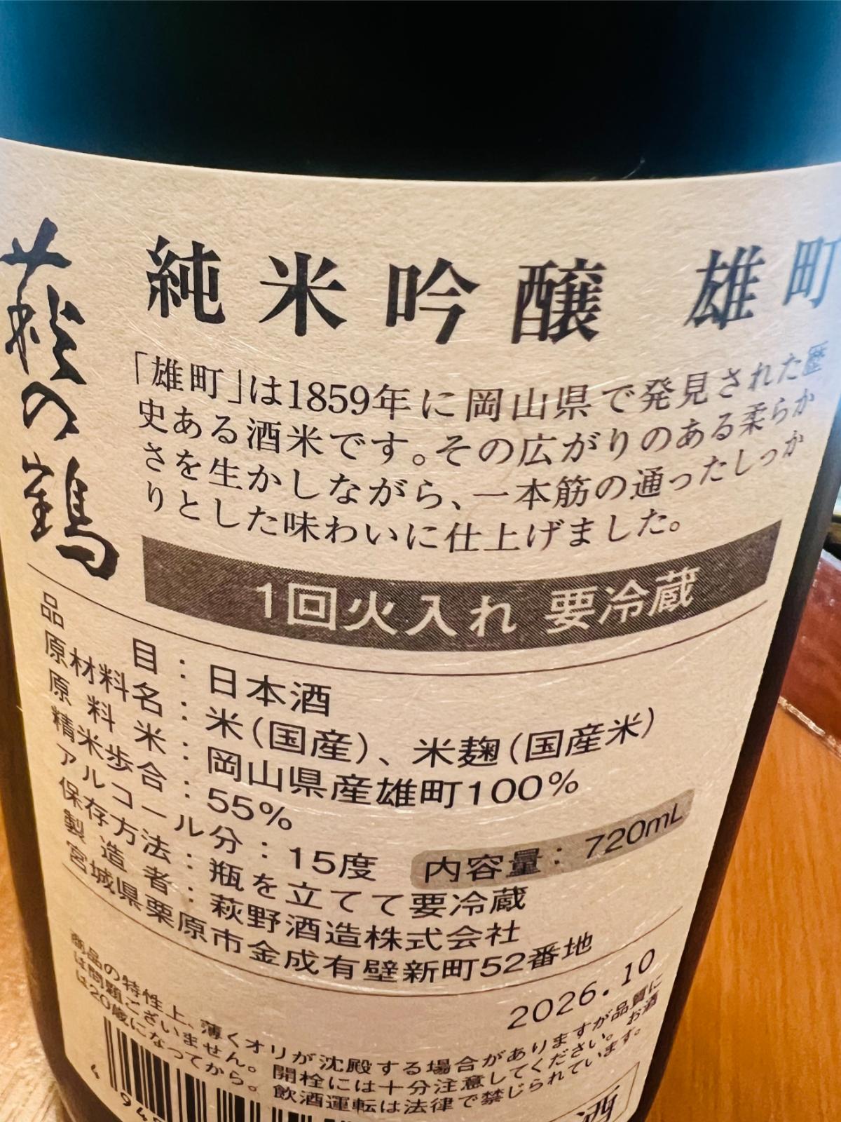 萩の鶴 純米吟醸 雄町の裏面ラベル接写。岡山県産雄町100％使用、精米歩合55％、アルコール分15度、一回火入れ・要冷蔵の表記と、雄町の柔らかさを生かしながら一本筋の通ったしっかりとした味わいに仕上げた旨の説明が確認できる。