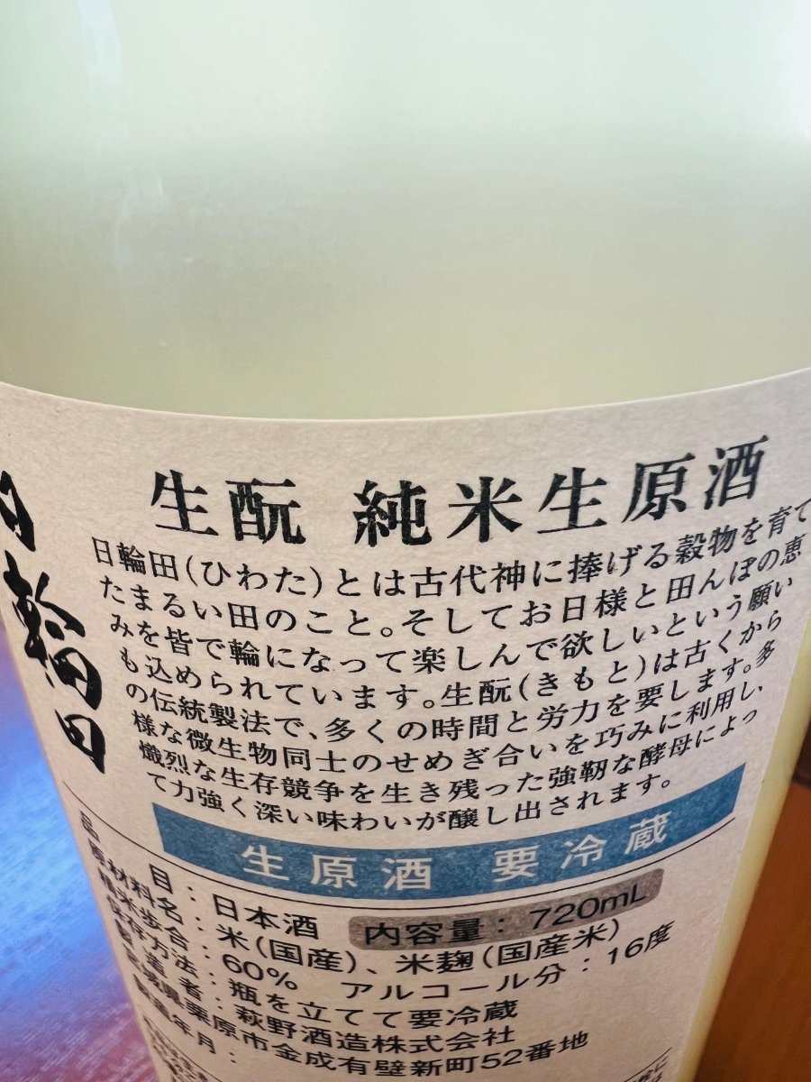 「日輪田 生酛 純米生原酒」の裏面ラベル。ブランド名の由来である「古代神に捧げる穀物を育てたまるい田」への想いと、伝統的な生酛造りによる力強く深い味わいについての説明が記されています。精米歩合60％、アルコール分16度、要冷蔵といった品質保持のための詳細スペックが確認できる、製品情報の画像です。