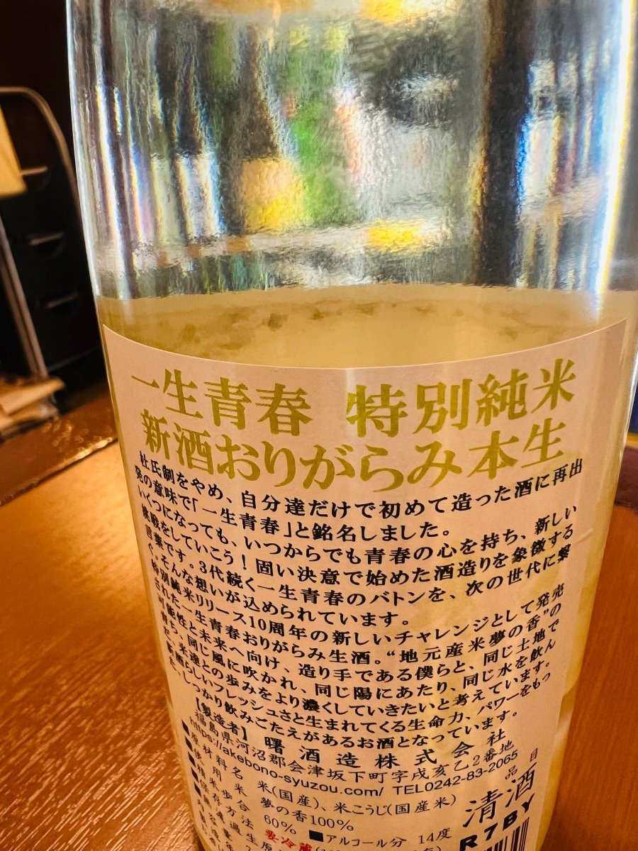 福島・曙酒造「一生青春（いっしょうせいしゅん）特別純米 新酒おりがらみ本生」の裏ラベル詳細。1997年、自分達だけで造り始めた酒に再出発の意味で命名された由来が記されています。「いつからでも青春の心を持ち、新しい挑戦をしていこう」という固い決意と、3代続くバトンを次世代へ繋ぐ想いが込められたラベルの画像です。