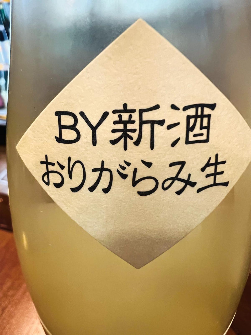 一生青春 特別純米 新酒おりがらみ本生 R8BYの首掛けラベル接写。福島県会津坂下町・曙酒造の新酒。淡い黄色の菱形ラベルに「BY新酒 おりがらみ生」と記載され、瓶の中にはおりがらみ特有の白く濁った酒質が確認できる。2026酒造年度の搾りたて無濾過生酒。