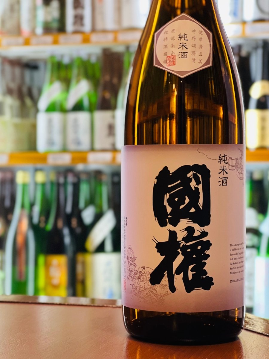 国権酒造の「国権 純米酒」1800mlの一升瓶。ほどよい酸味と苦みが調和した、芯のある「正統派の純米酒」です。お燗にすることで焼き芋のような甘い香りが広がり、味わいも驚くほど柔らかく滑らかに変化します。湯豆腐やすき焼き、ホタテのバター焼きなど、薄味から濃い目の料理まで幅広く寄り添う、晩酌の相棒にふさわしい大定番の高級酒です。