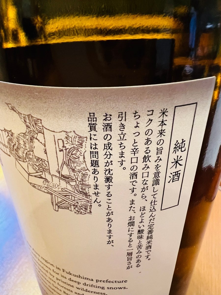 福島・国権酒造の「国権 純米酒」のラベル背面。米本来の旨みを活かしたコクのある飲み口と、ほどよい酸味・苦みが調和した辛口の味わいについての説明が記されています。「お燗にすると一層旨さが引き立つ」というお勧めの飲み方や、品質に関する注意書きが確認できる、製品詳細の画像です。