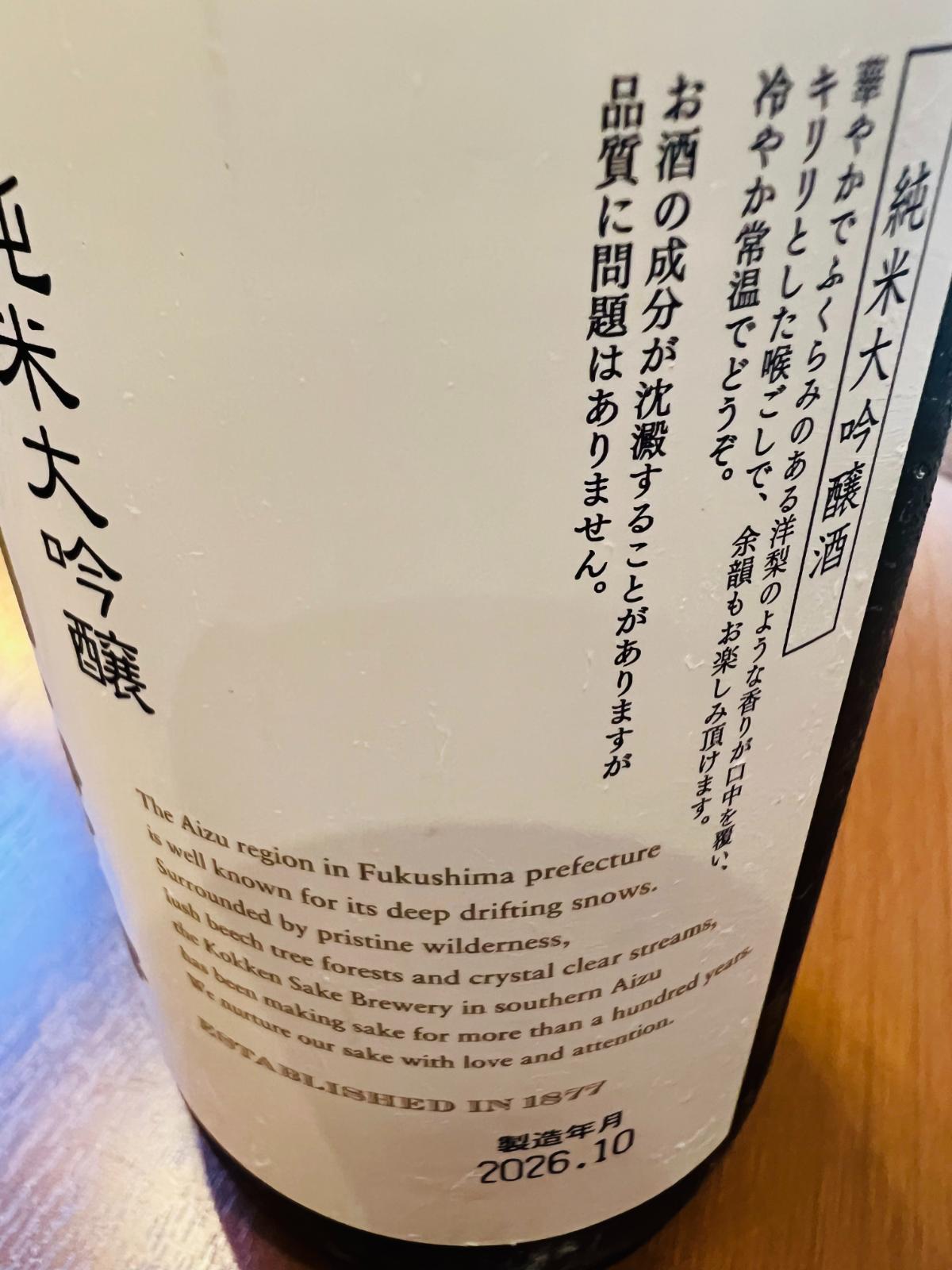 国権 純米大吟醸 金ラベルの反対側ラベル接写。華やかでふくらみのある洋梨のような香りと、キリリとした喉ごし、余韻を楽しめることや、冷や・常温がおすすめである旨が記載されている。