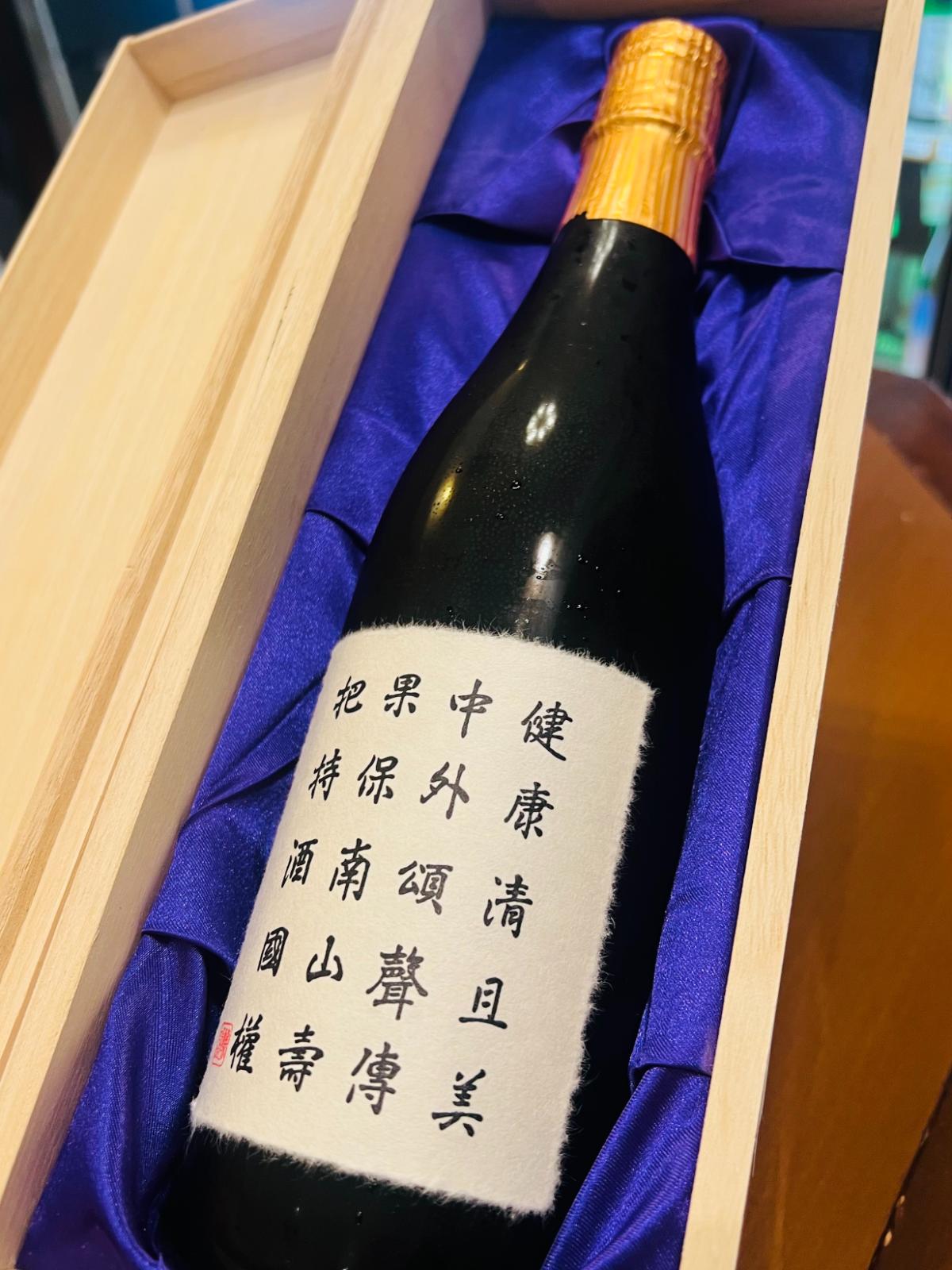 国権 特撰大吟醸 斗瓶囲いを専用木箱に収めた状態。紫色の布地に包まれた瓶と、生成り色の和紙調ラベルが見える開封時の様子。