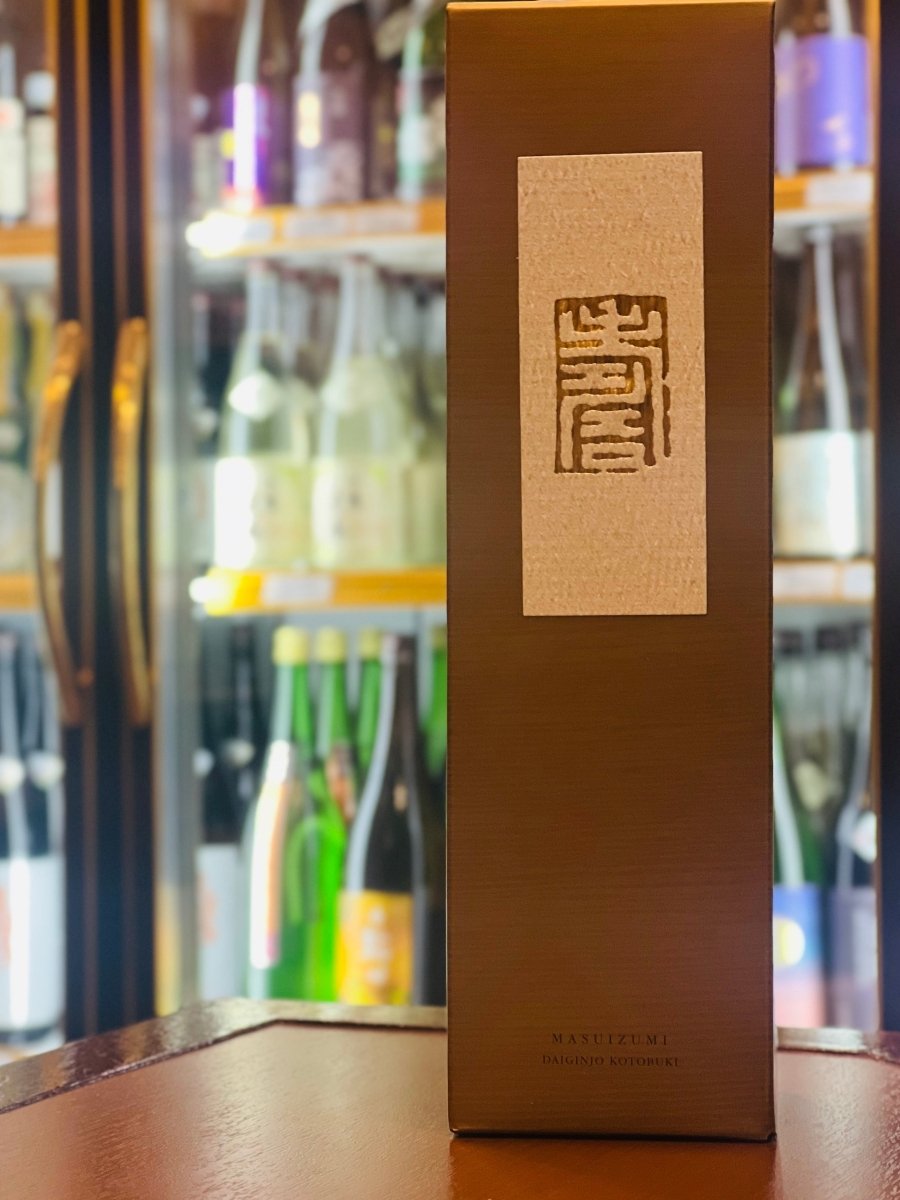 富山・桝田酒造店の最高級ライン「満寿泉 大吟醸 寿」の化粧箱。深みのあるブロンズゴールドの箱に、和紙のような質感のラベルと朱印風のロゴが施された格調高いデザイン。シャインマスカットのような気品ある香りを湛えた「酒の芸術品」を包む、贈り物や記念日にふさわしい贅沢なパッケージです。