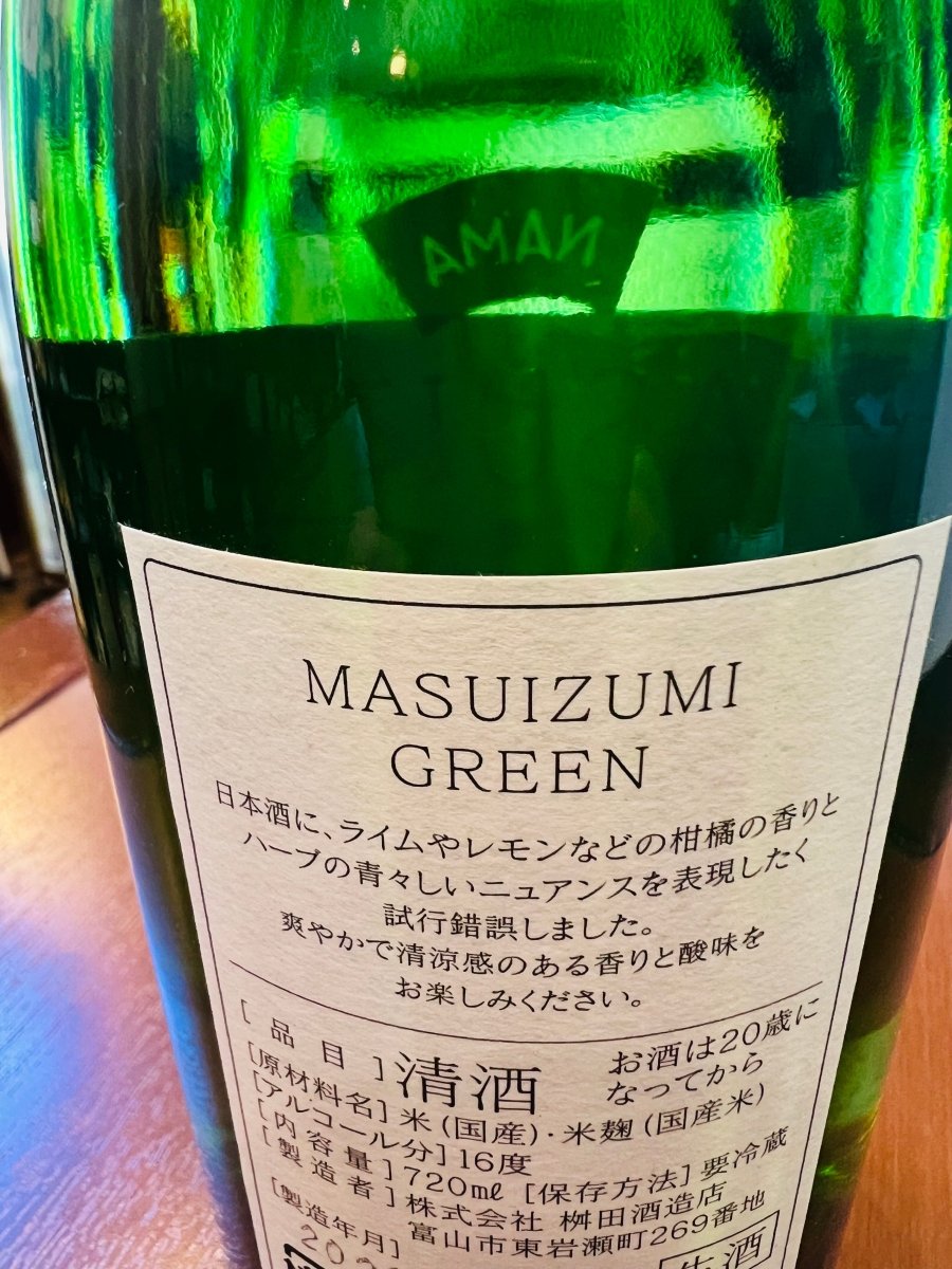 「満寿泉 GREEN 生」720mlボトルの裏面ラベル。日本酒にライムやレモンなどの柑橘の香りと、ハーブの青々しいニュアンスを表現したという蔵元の試行錯誤とこだわりが綴られています。原材料（国産米・米麹）、アルコール分16度、内容量720mlといった基本情報のほか、爽やかで清涼感のある香りと酸味を楽しむための「要冷蔵」の案内が確認できる製品詳細の画像です。