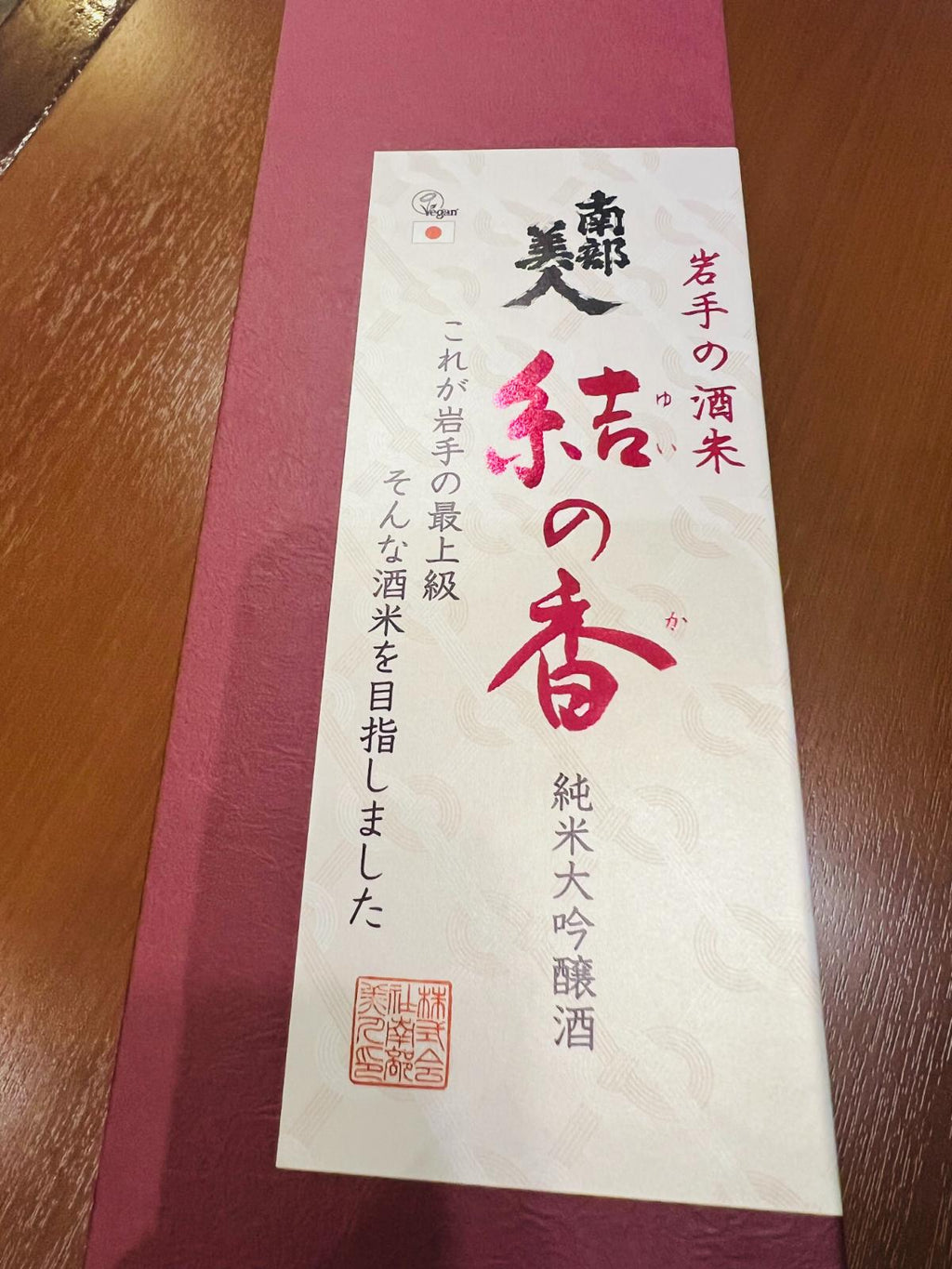 南部美人 純米大吟醸 結の香の専用化粧箱アップ。えんじ色の箱に「岩手の酒米 結の香」「これが岩手の最上級 そんな酒米を目指しました」と記され、純米大吟醸酒であることやVegan認証ロゴも確認できる贈答用化粧箱。
