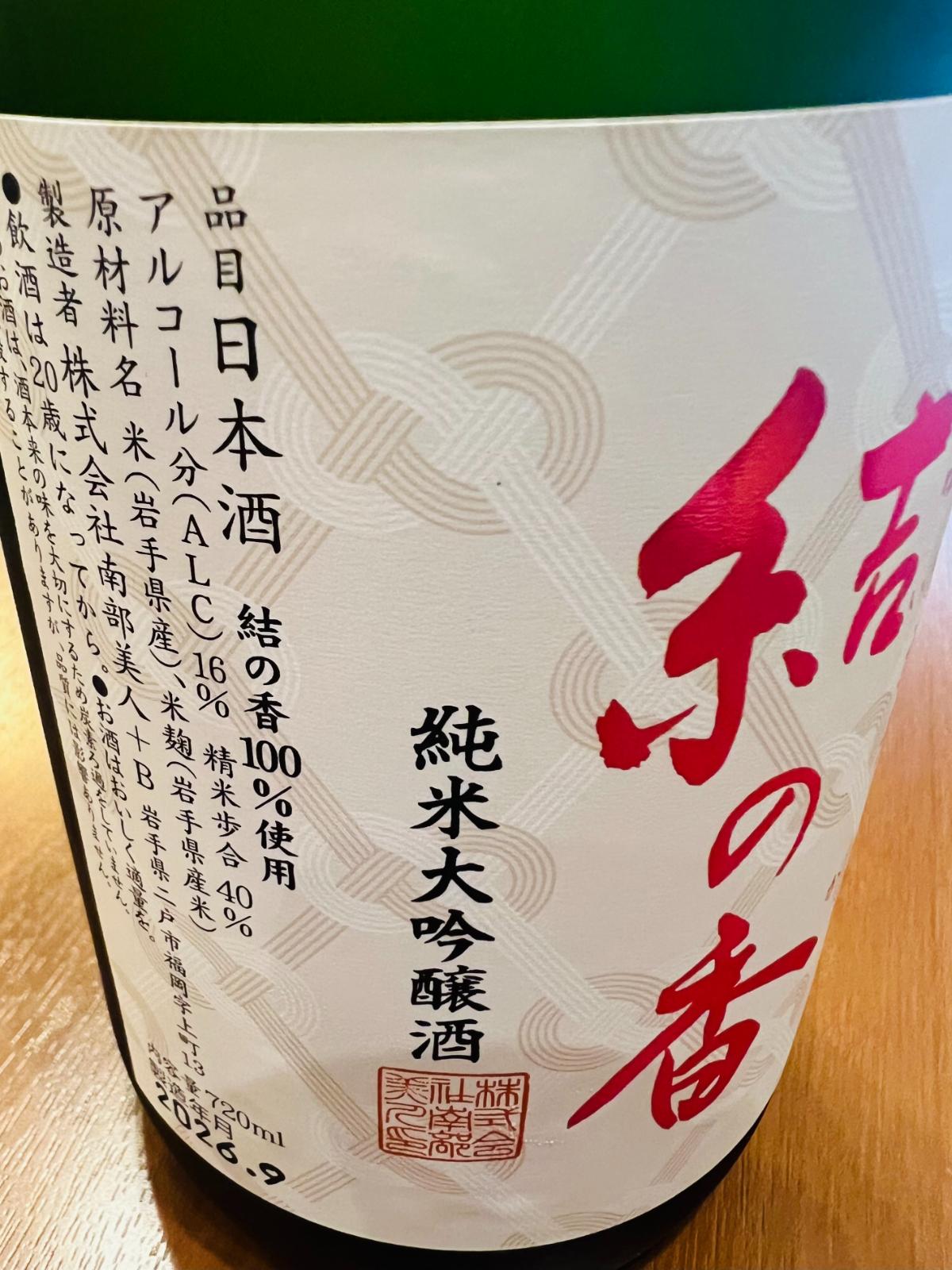 南部美人 純米大吟醸 結の香のラベル接写。水引のあわじ結びを思わせる和柄を背景に「結の香」「純米大吟醸酒」の表記が入り、岩手県産「結の香」100％使用、精米歩合40％、アルコール分16％、内容量720mlなどのスペックが記載されている。