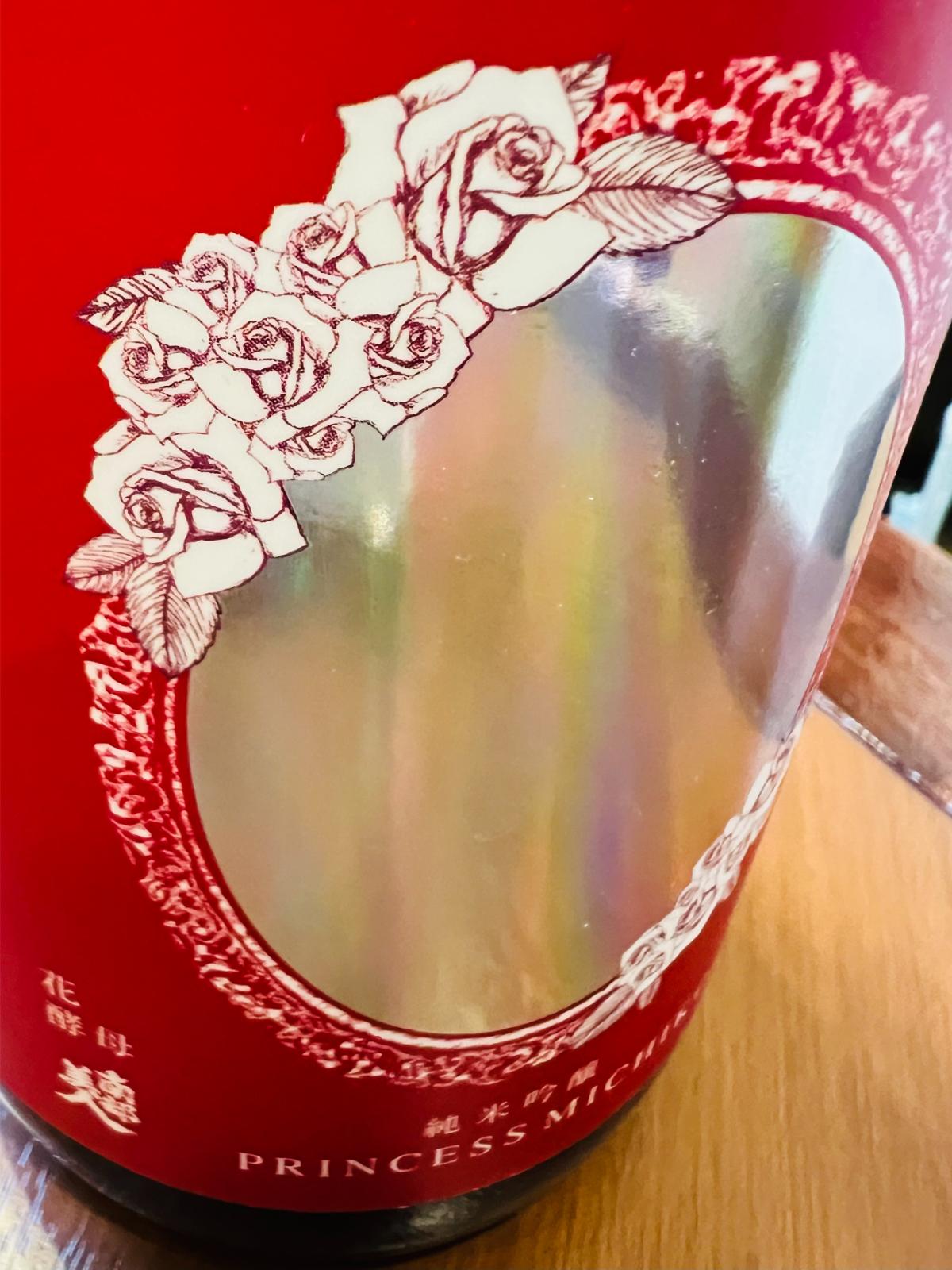 南部美人 純米吟醸 プリンセスミチコ 720ml。バラをあしらった赤いラベルと、鏡のように反射する銀色の中央部分を接写。