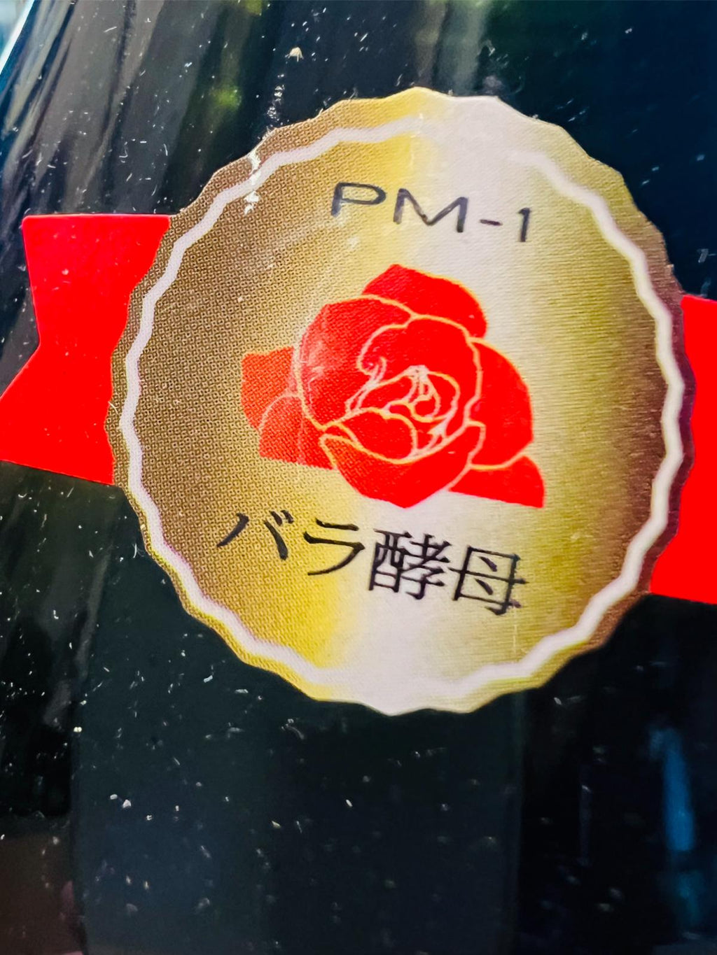 南部美人 純米吟醸 プリンセスミチコ 720ml。ボトル首元に貼られた「PM-1 バラ酵母」シールの接写。
