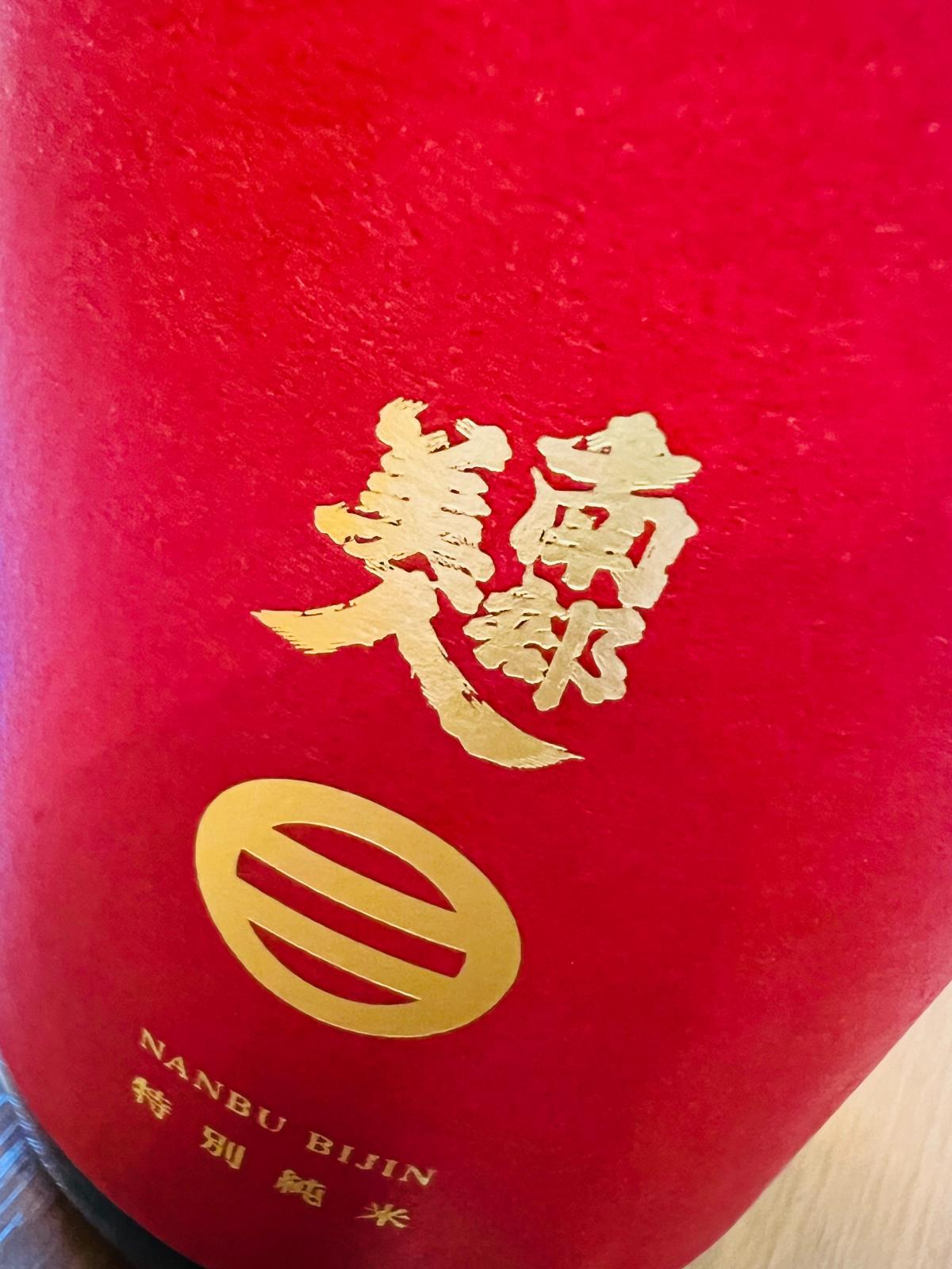 南部美人 特別純米の正面ラベル接写。深い赤色のラベルに金色で「南部美人」のロゴと「特別純米」の文字があしらわれた、岩手県二戸市・南部美人の定番純米酒のラベル。