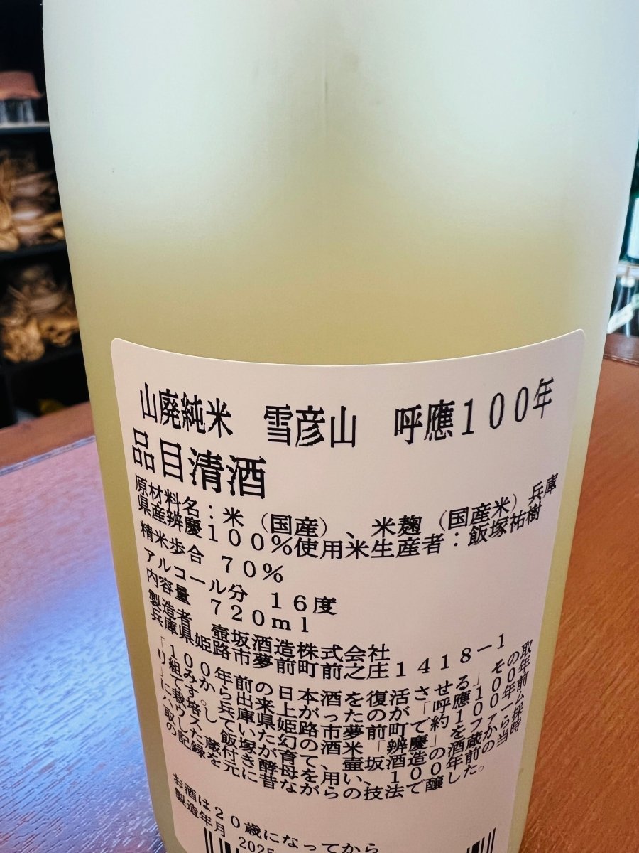 兵庫・壺坂酒造「山廃純米 雪彦山 呼應100年」の裏面ラベル詳細。「100年前の日本酒を復活させる」という試みから誕生した背景が記されています。地元・姫路市夢前町で約100年前に栽培されていた幻の酒米「辨慶」を復活させ、酒蔵から採取した蔵付き酵母と当時の記録を元に醸された、歴史と呼応する製品スペック。精米歩合70%、アルコール分16度など、昔ながらの技法で醸された「滋味深く綺麗な山廃」のこだわりを確認できる画像です。