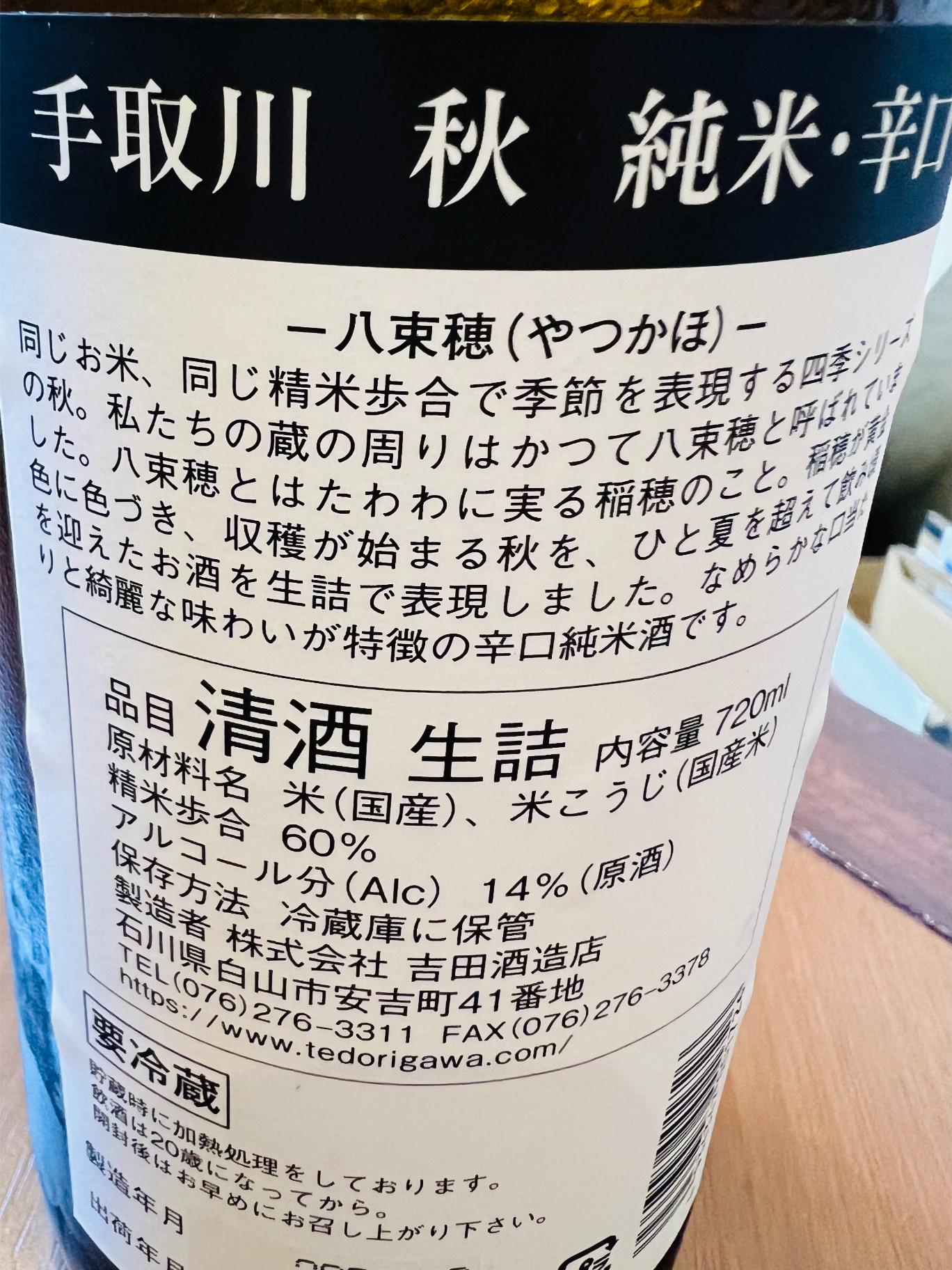 手取川 秋 純米辛口 生詰 720mlの裏面ラベル。石川県白山市・吉田酒造店が国産米を60％まで磨いて醸すアルコール14度の原酒。秋の実り「八束穂」をイメージし、なめらかな口当たりと綺麗な味わいを特徴とする辛口純米酒であることや、要冷蔵・生詰の表示を記載。