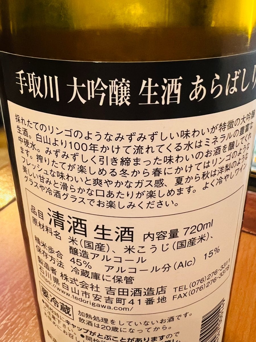 手取川 あらばしり 大吟醸 生酒 1800mlの裏面ラベル。石川県白山市の吉田酒造店による製造情報、精米歩合45%、アルコール分15%などのスペックに加え、白山からの百年水を使用した酒造りのこだわりが記載されています。