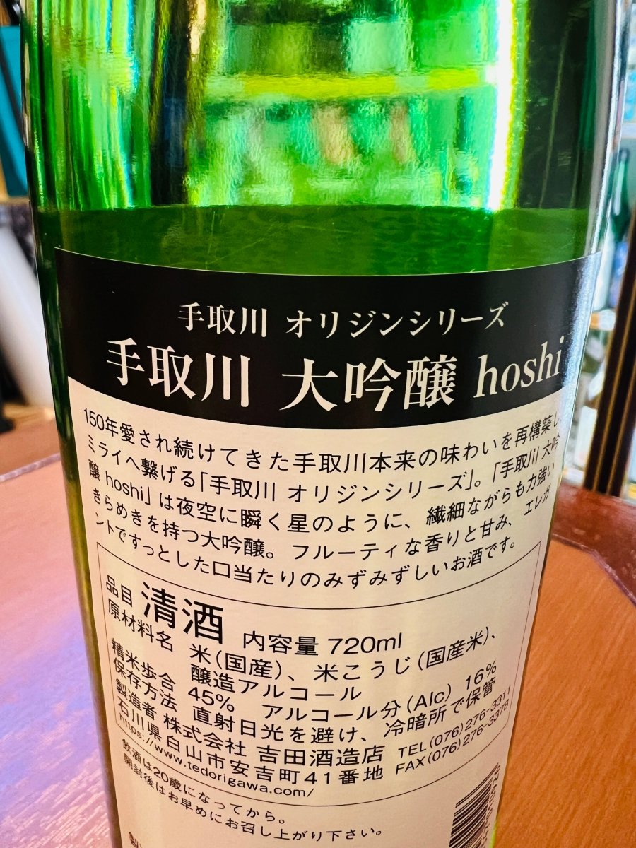 石川県・吉田酒造店「手取川 大吟醸 hoshi」裏面ラベル。手取川オリジンシリーズの説明文や原材料、精米歩合45%、アルコール度数16%、内容量などのスペック表記が確認できる商品情報ラベルの拡大写真。