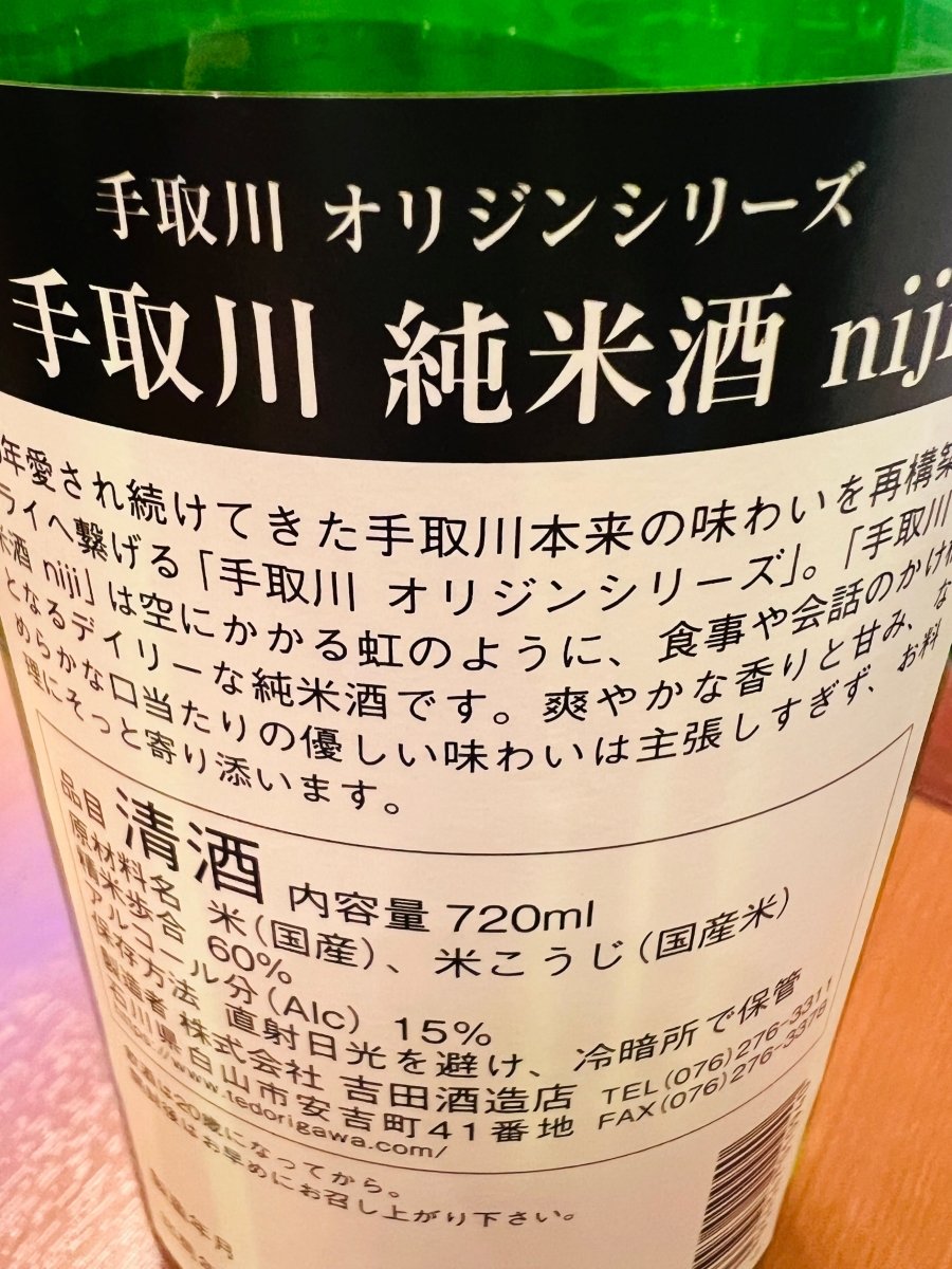 手取川 純米酒 niji の裏面ラベル。オリジンシリーズの説明文と原材料・精米歩合60％・アルコール15度などのスペック表記が確認できる石川県吉田酒造店の日本酒ボトル。