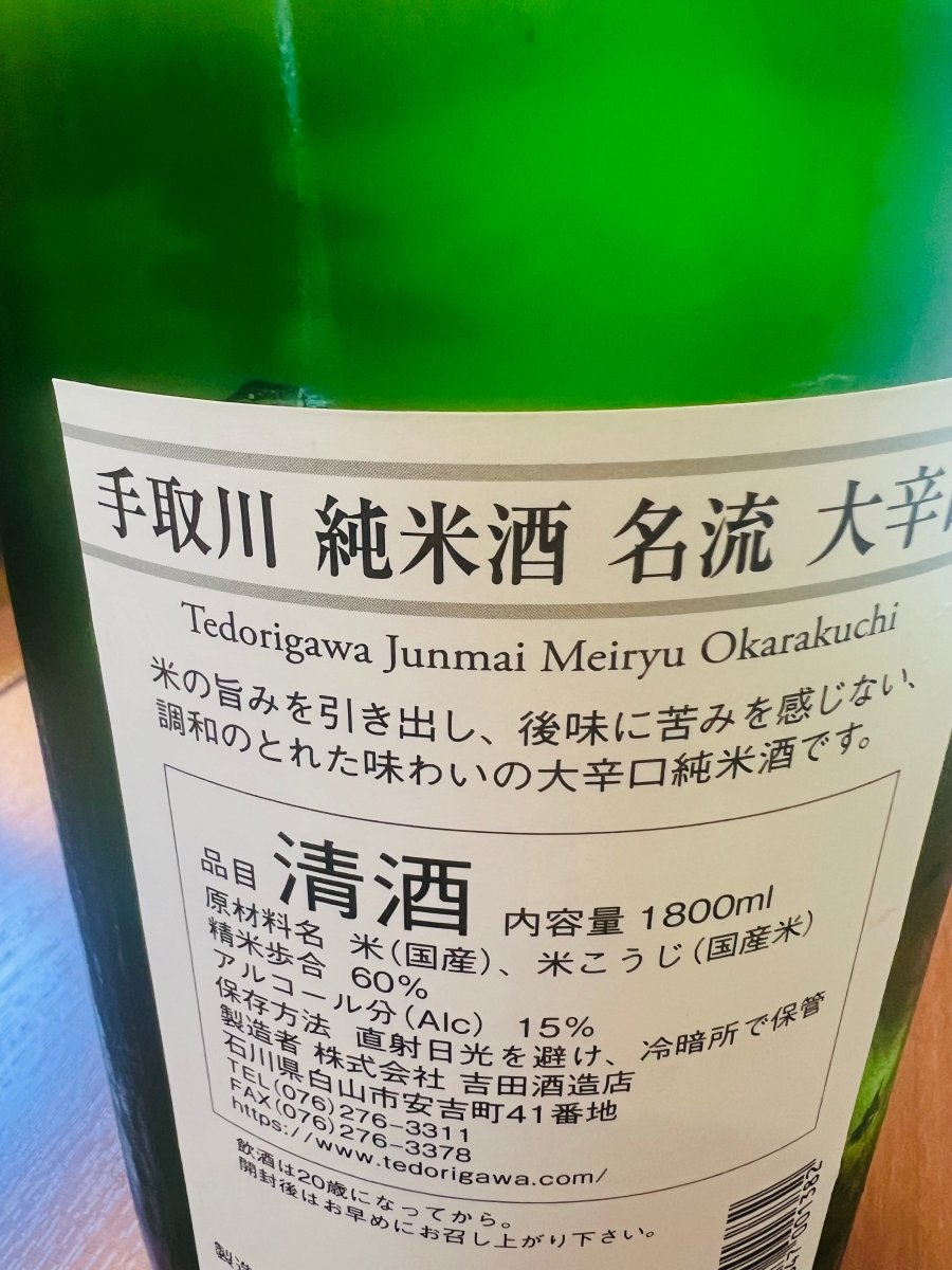 「手取川 純米酒 名流 大辛口」の裏ラベル記載。米の旨みを引き出し、後味に苦みを感じない調和のとれた味わいであることが紹介されています。石川県白山市の蔵元・吉田酒造店による、大辛口純米酒としてのこだわりと正確な製品スペックが記載されています。