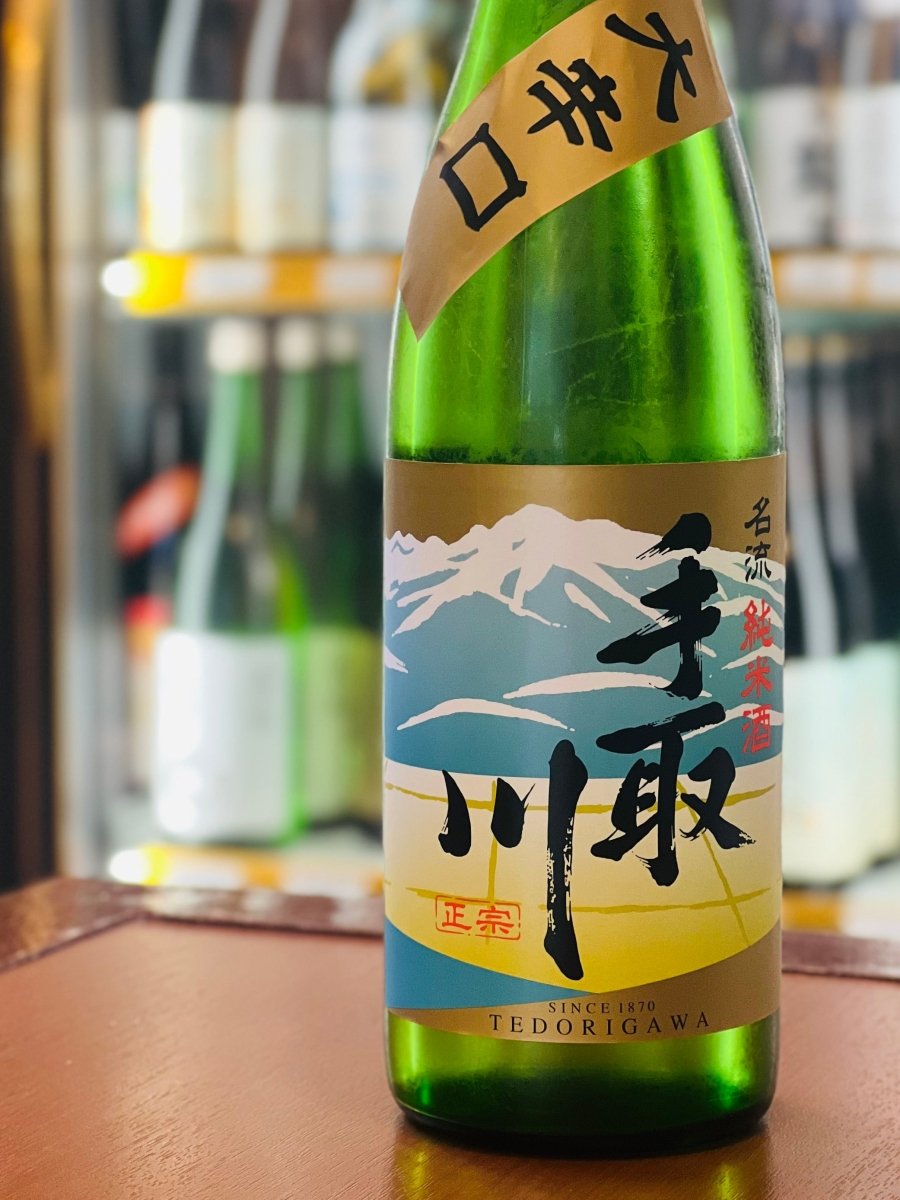 石川県・吉田酒造店の「手取川 純米酒 名流 大辛口」720ml瓶。白山が描かれた茶色＆ブルーのラベルに「大辛口」の肩貼りが特徴です。日本酒度+10のキレがありながら、米の旨みをしっかりと感じるまろやかな味わい。かつおのたたきや鮎の塩焼きなど、素材の旨みが引き立つ料理に最適な辛口純米酒です。