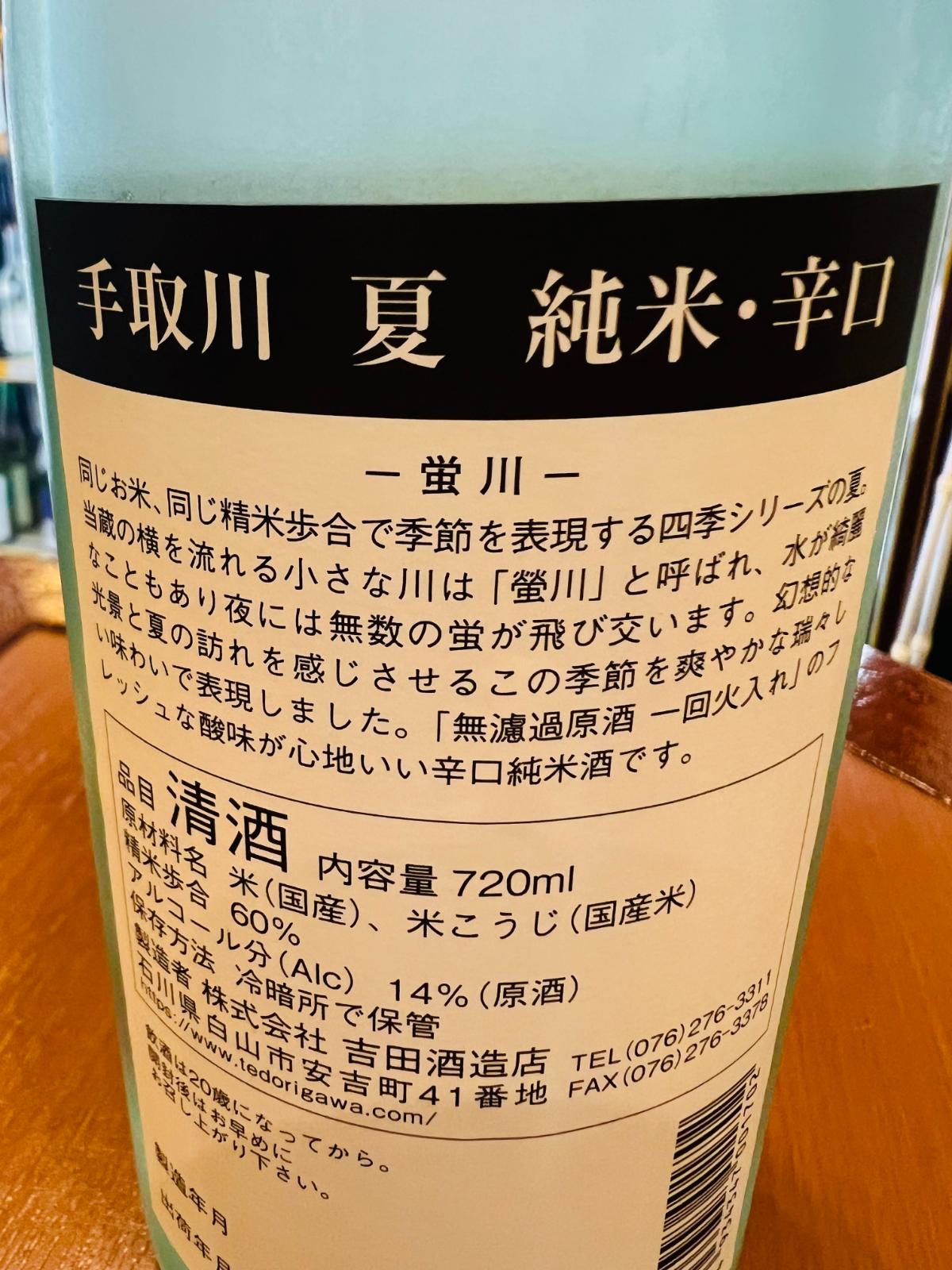 手取川 夏 純米辛口の裏面ラベル。蔵の横を流れる螢川と夏の夜の蛍をイメージした、無濾過原酒一回火入れの瑞々しく心地よい辛口純米酒であることを確認できる記載。