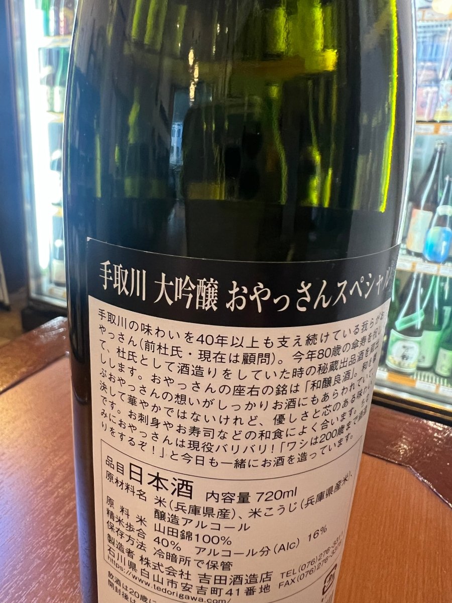 石川・吉田酒造店「手取川 大吟醸 おやっさんスペシャル」の裏ラベル詳細。40年以上蔵を支え続けてきた前杜氏（現顧問）の「おやっさん」こと山本輝幸氏の傘寿を祝し、杜氏時代の秘蔵出品酒を特別に蔵出しした物語が記されています。「和醸良酒」を座右の銘とするおやっさんの想いが詰まった、優しさと芯のある味わいを伝える画像です。