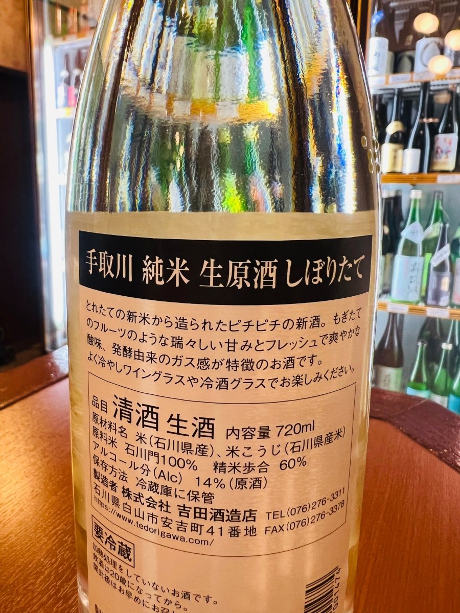 石川・吉田酒造店「手取川（てどりがわ）純米 生原酒 しぼりたて」の裏ラベル詳細。とれたての新米から造られたピチピチの新酒であることが記されています。もぎたてのフルーツのような瑞々しい甘みとフレッシュで爽やかな酸味、発酵由来のガス感が特徴。よく冷やしてワイングラスや冷酒グラスで楽しむことが推奨されている、造りたての魅力を伝える画像です。