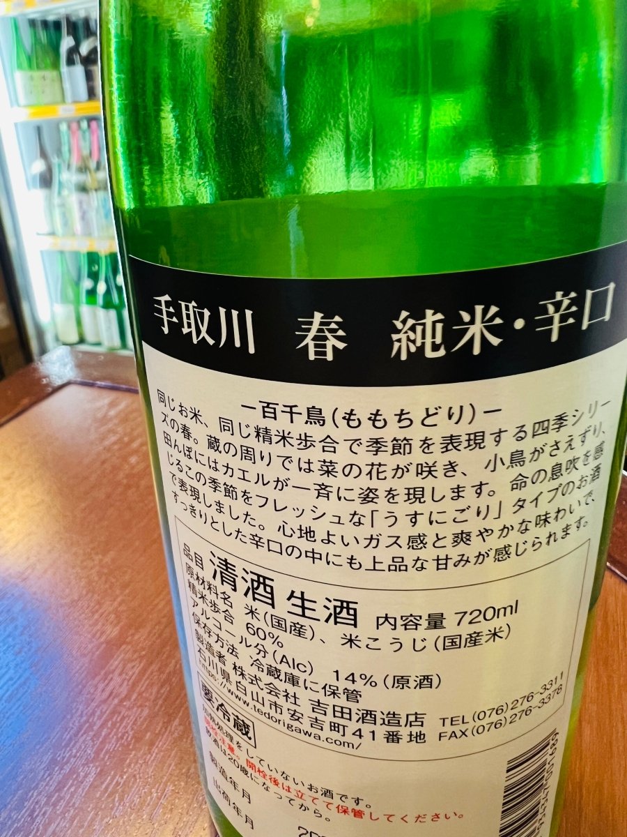 石川県・吉田酒造店の季節限定酒「手取川 春 純米・辛口 百千鳥（ももちどり）」の裏ラベル画像。原材料（山田錦・石川門）、精米歩合60%、アルコール分14%などの詳細スペックを記載。フレッシュな「うすにごり」タイプで、春の訪れを感じさせる爽やかな味わいの説明が添えられています。