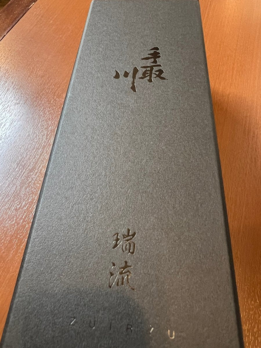 石川・吉田酒造店の最高峰ライン「手取川 瑞流（ずいりゅう）」の専用ギフト箱。マットな質感の漆黒の箱に、銀色に輝く「手取川」と「瑞流」の文字が刻印された、プレミアムな風格を漂わせるデザインです。令和6年全国新酒鑑評会にて、山廃造りとして史上初の金賞を受賞した歴史的な逸品を収めるに相応しい、洗練された高級パッケージ画像です。