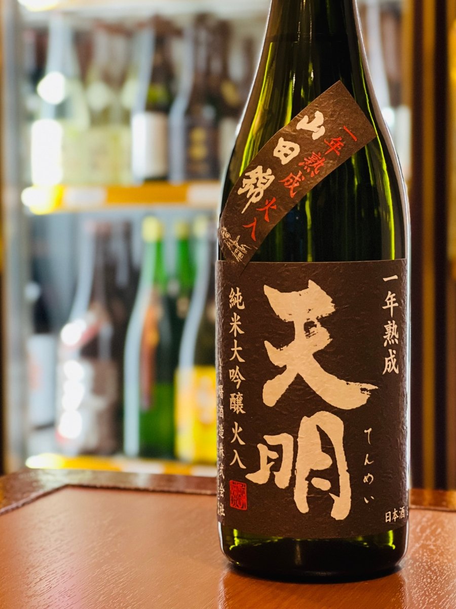 福島・曙酒造の「茶色の天明（てんめい）純米大吟醸 火入 一年熟成50」720mlボトル。山田錦を50％まで磨き、一年間低温で生熟成させた後に火入れ急冷した、創生期から続く伝統的スタイルの限定酒です。熟した葡萄やイチゴを思わせる上品な香りと、つるふわな口当たり、遅れて広がる瑞々しい酸が特徴。銀だら西京焼きやクリームチーズ酒盗和えなど、少し濃いめの料理とじっくり味わいたい四合瓶サイズです。