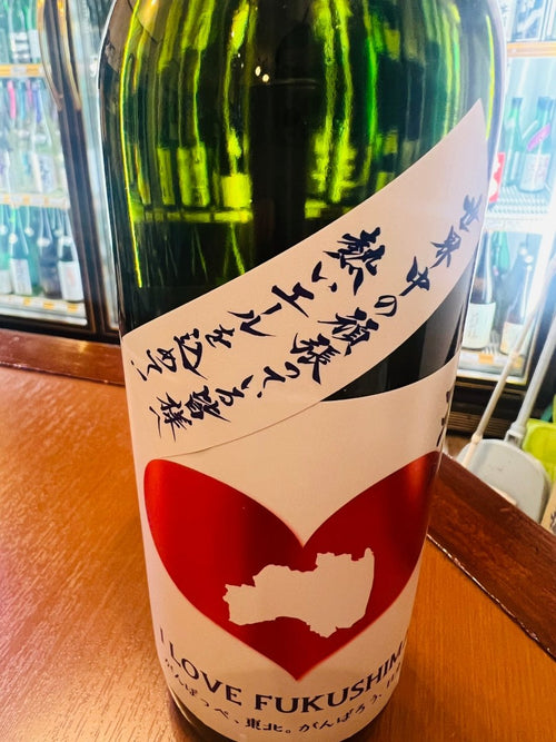 福島・曙酒造の日本酒「ハート天明」ボトルの首掛けメッセージラベル。「世界中の頑張っている皆様へ 熱いエールを込めて！」と書かれている。