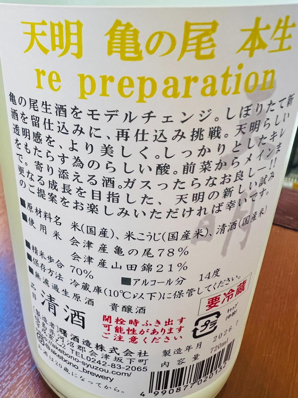 天明 亀の尾本生 re preparation 貴醸酒の裏面ラベル。福島県会津坂下町・曙酒造が、会津産亀の尾78％と会津産山田錦21％を使用し、精米歩合70％、アルコール14度で醸す無濾過生原酒の貴醸酒。清酒を留仕込みに用いた再仕込みと、開栓時の吹き出し注意について記載。