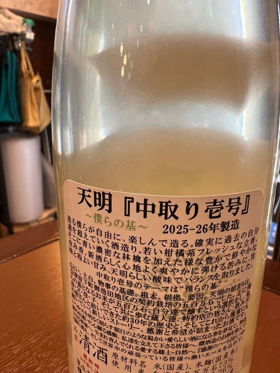 福島・曙酒造「天明 中取り壱号 〜僕らの基〜」の裏ラベル詳細。天明の始まりの米である会津坂下町御池田地区産の五百万石を「僕らの基（もとい）」と定義し、約30年の歴史とこれからの新しいストーリーへの感謝が綴られています。若手蔵人たちが自由に楽しみながら、過去の自分たちを確実に超えていく決意とともに、郷土や自然への愛が記された情熱的なラベル画像です。