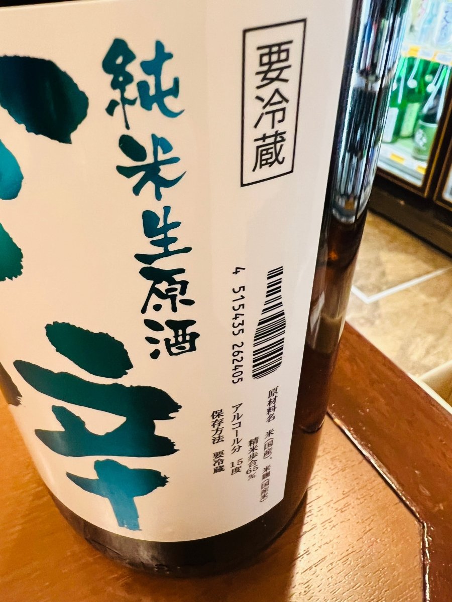 秋田県・山本酒造店の日本酒「山本 ど辛 純米 生原酒」のラベル側面。純米生原酒の表記と「要冷蔵」の注意表示があり、JANコードが酒瓶の形にデザインされたおしゃれなラベル。